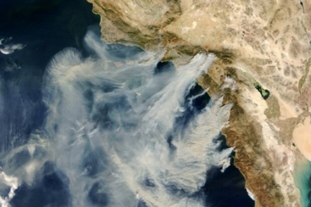 Picture showing massive plumes of smoke from wildfires in California in October 2003 as well as a graph depicting acres burned during California wildfires each year from 1971-2013